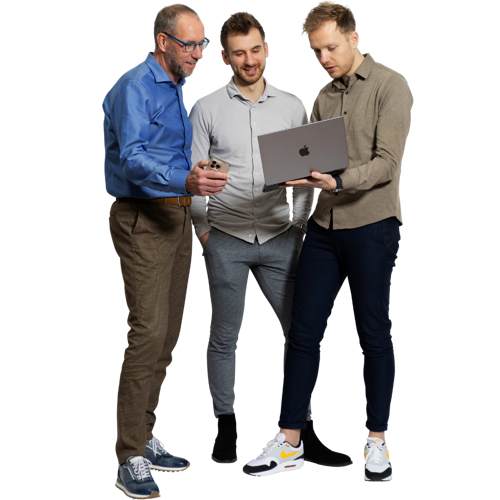 Drie mannen in formele kleding kijken samen naar een laptop. De man links draagt een blauw overhemd, de man in het midden een grijs shirt, en de man rechts een beige blouse. Ze staan ontspannen en zijn bezig met een gesprek over de laptop.